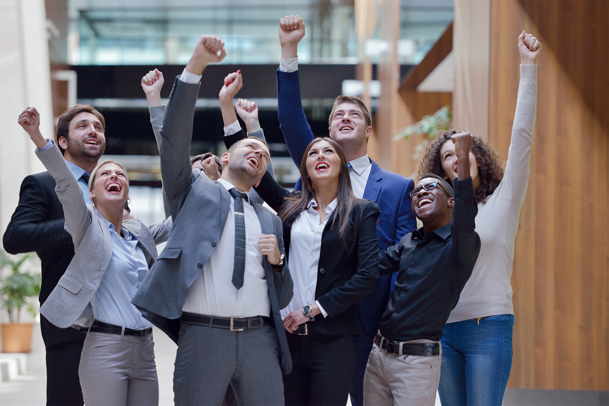 Group of excited employees with hands up